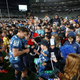 Life returns to normal in New Zealand without need for social distancing, as a crowd comes onto the field to get player autographs during round 1 of the Super Rugby Aotearoa match between the Blues and the Hurricanes at Eden Park on June 14, 2020 in Auckland, New Zealand.